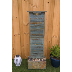 Natural Stone Floor Fountain with Light Rectangular Base Supports The water Wall, with River Stones Resting on The Bottom